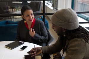 two people sitting at a table and talking