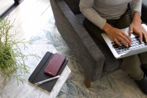 woman sitting on a chair and typing on a laptop