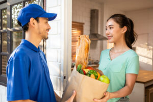 man delivering groceries to a woman's front door