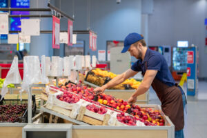 man stocking vegetables in a supermarket