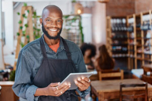 retail worker wearing an apron and holding a tablet 