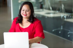 woman sitting at a table working on a laptop computer