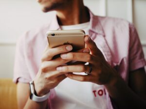 young person holding a mobile phone and typing on the mobile phone