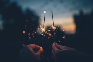 two hands holding sparklers 