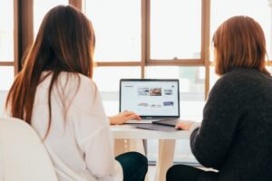 two women looking at a laptop computer